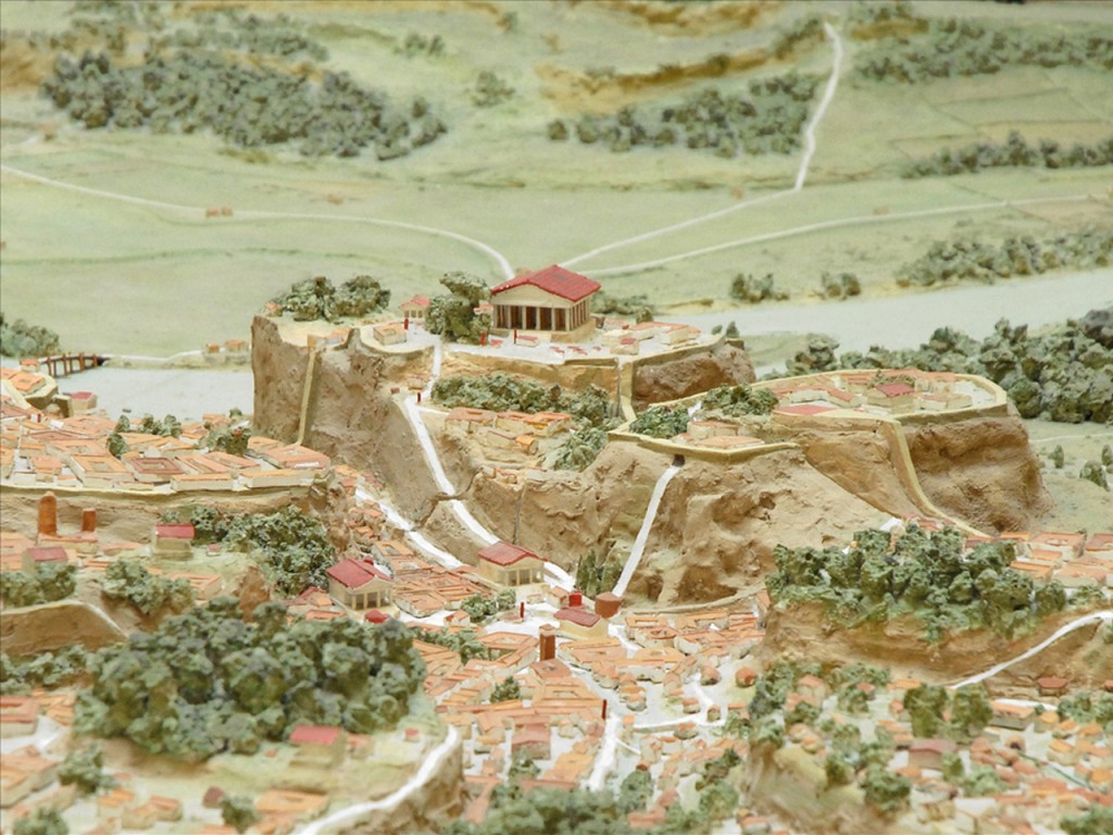 A more developed form of the settlement.  The Temple of Jupiter with its red roof still stands on the Capitoline hill, while buildings have now filled the valleys below.