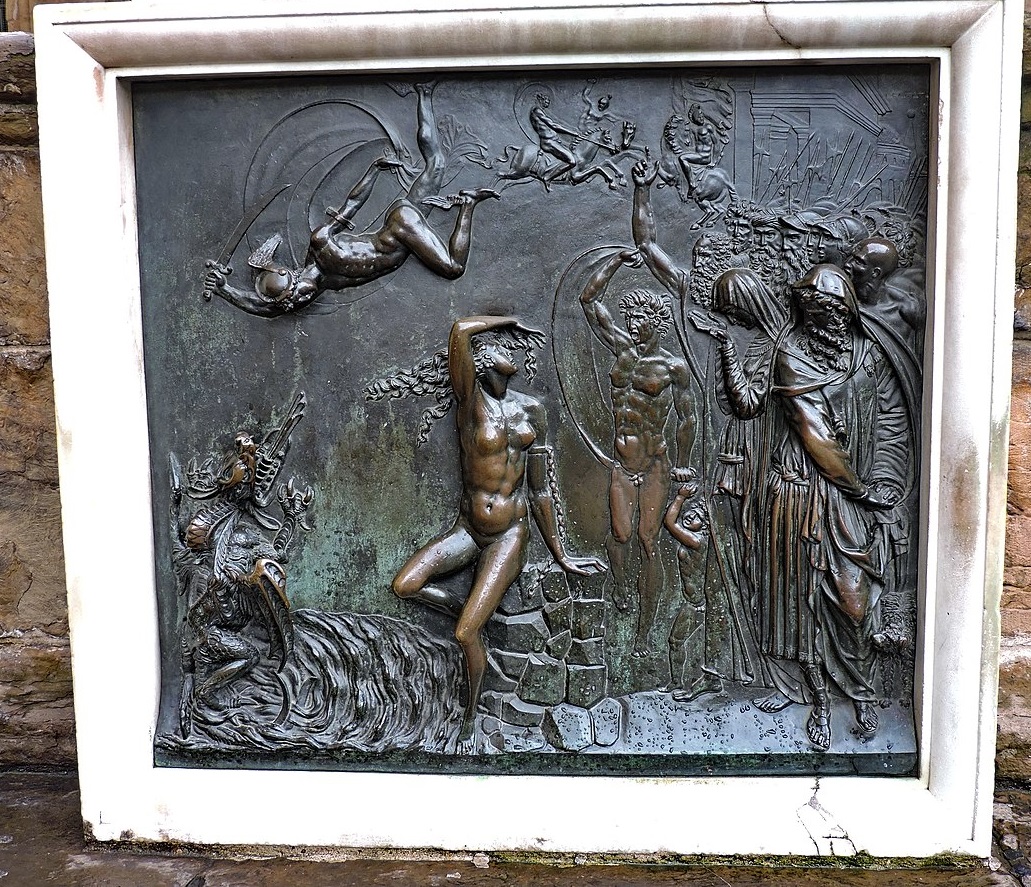 A photograph of the square bronze frieze described in the main text: in the middle Andromeda sits on a stack of stones which look conspicuously like the stones the Palazzo Vecchio itself is made of (the seat of government and symbol of the city). Above her, Perseus flies down with upraised sword to slay the sea dragon which threatens her from the bottom left. To the right, mourning citizens watch the dramatic scene, but above and behind them men on horses clash and the pikes and halberds of German-style soldiers of the era the statue was made stick up above the crowd.